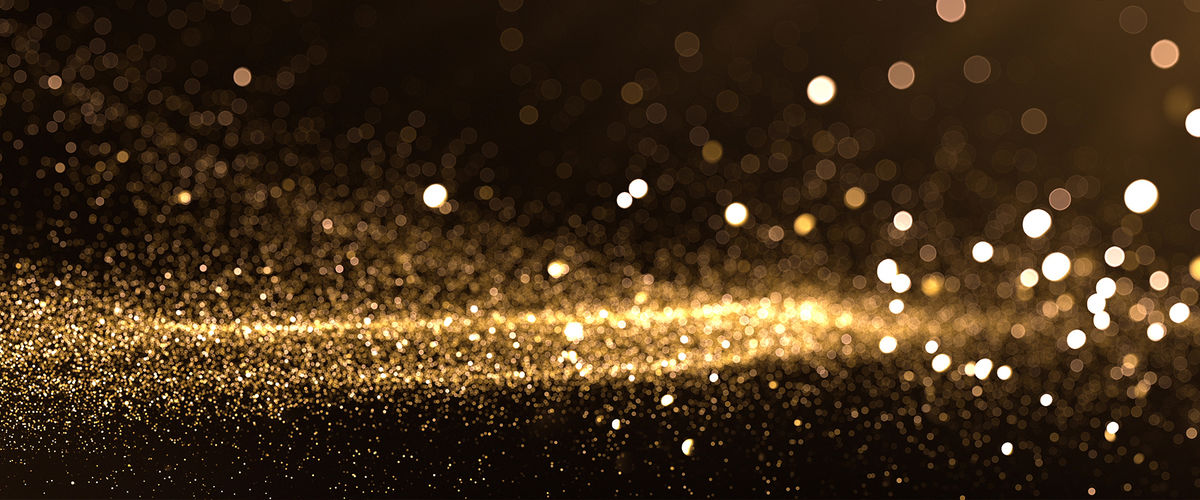 gold glitter in an out of focus on a dark background