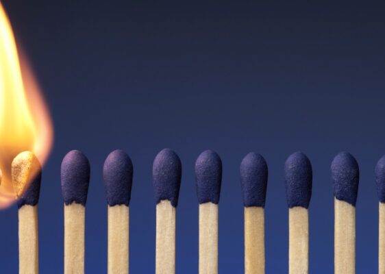 Picture of a lit match next to a row of unlit matches